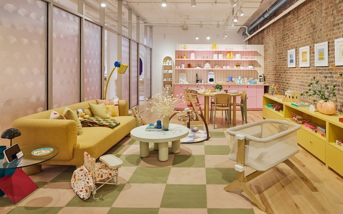The Apartment inside Babylist's New York showroom, a 600-square-foot furnished room with a bassinet, play mat and yellow sofa.