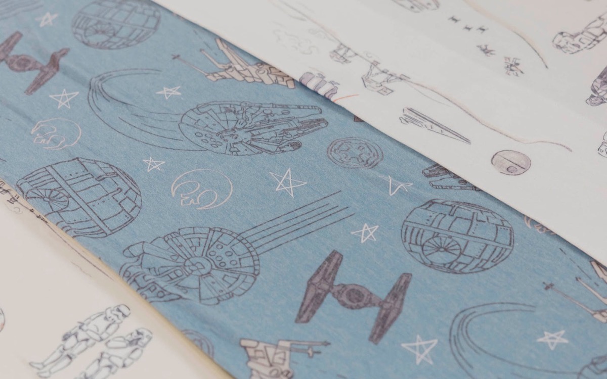 The Tatooine twin cloud comforter on a bed, folded back to show the blue Star Wars print on its reverse side.