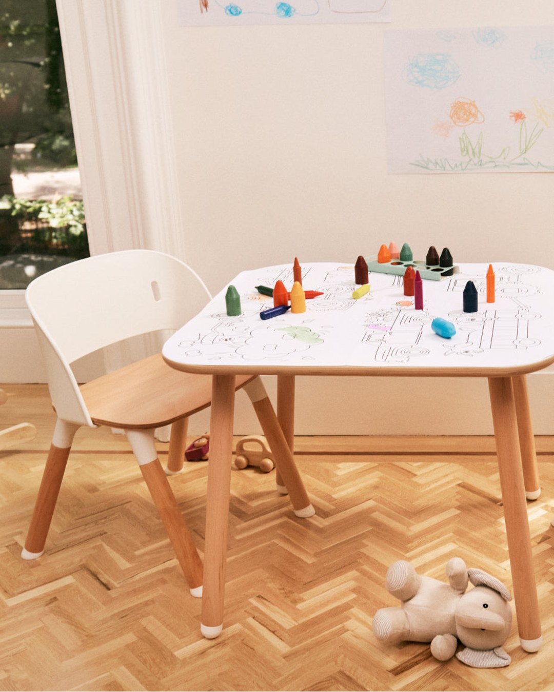 The Lalo Chair II in play chair mode at a small table covered in crayons.