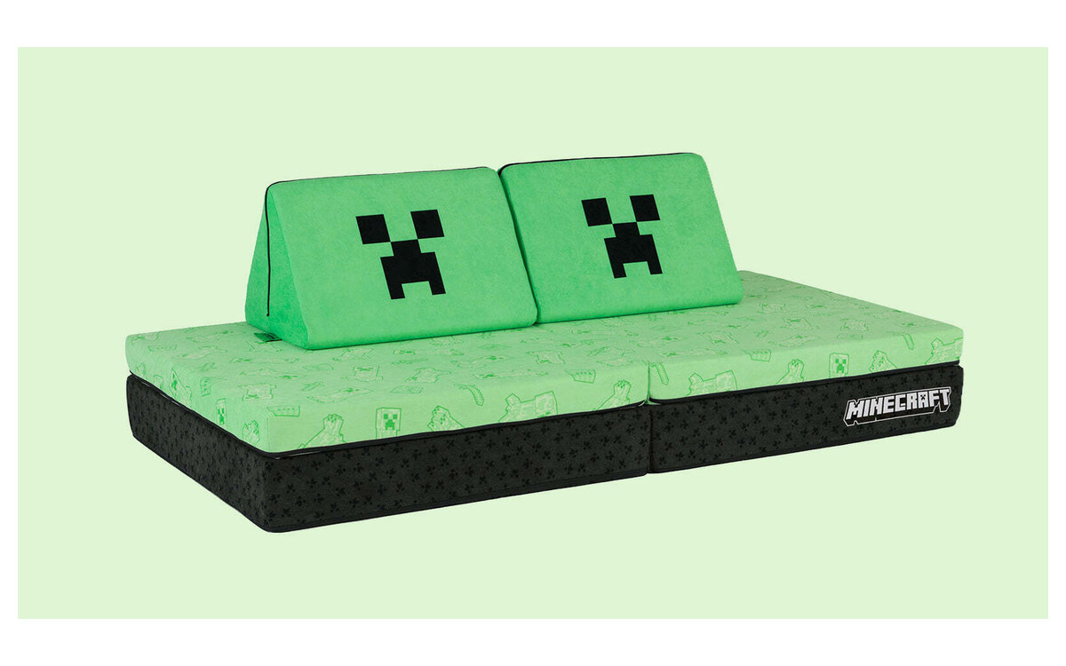 The Minecraft Nugget play couch, pale green with Creeper-face pillows and a near-black base, on a pale green background.