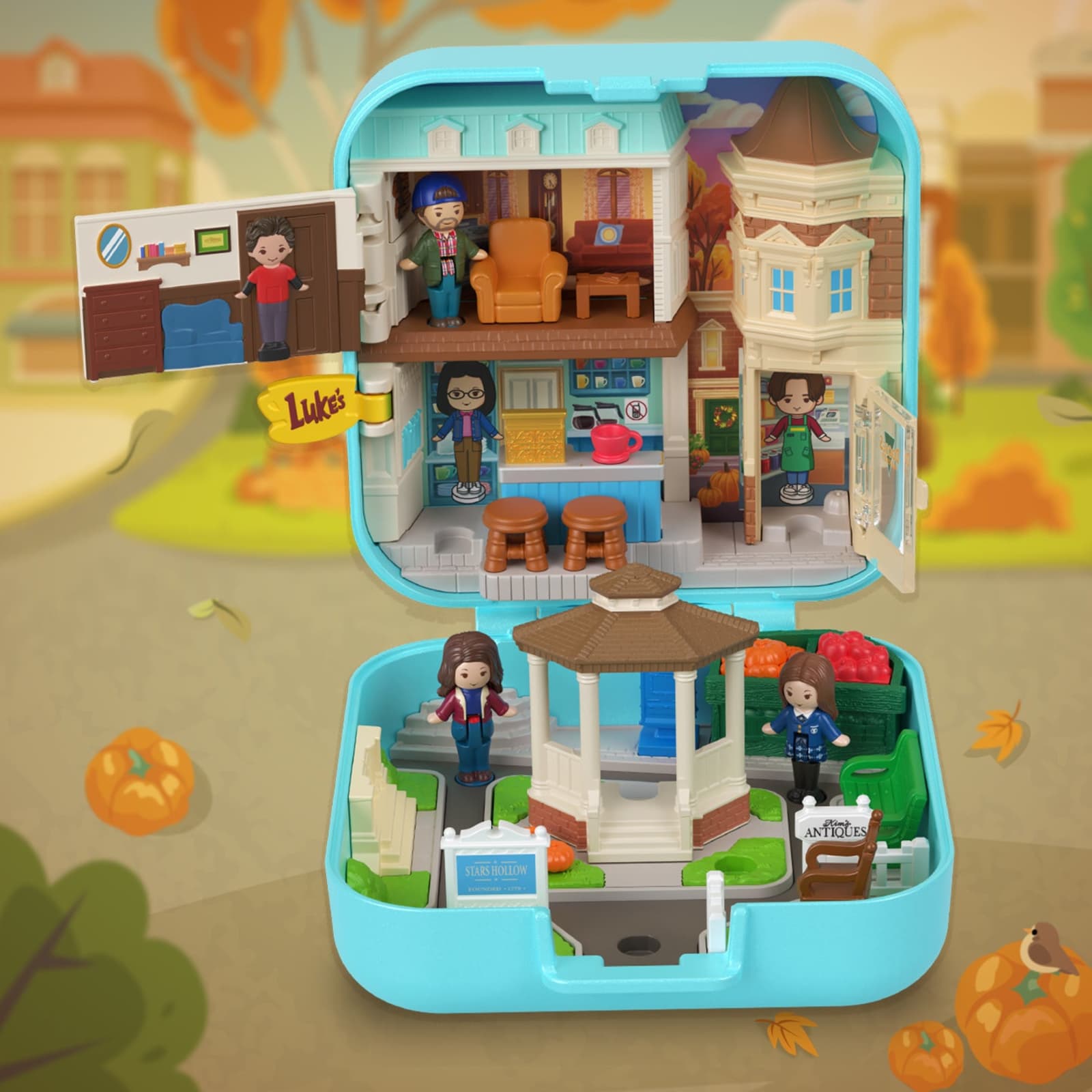 The Gilmore Girls Polly Pocket compact open, showing the Stars Hollow gazebo, Luke's Diner and Doose's Market with the three micro figures.