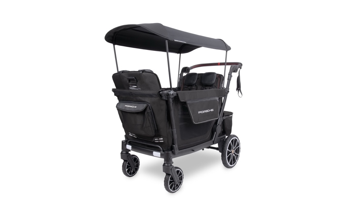 The WonderFold x Porsche four-seat stroller wagon in black, with the canopy up and Porsche crests on the rear wheels.